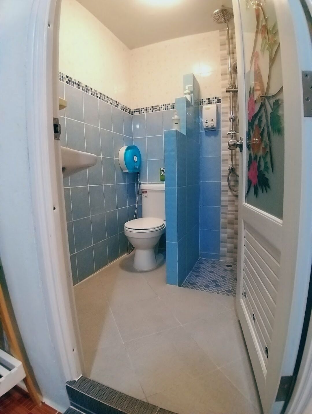 Une salle de bain avec des toilettes, un lavabo et une douche.