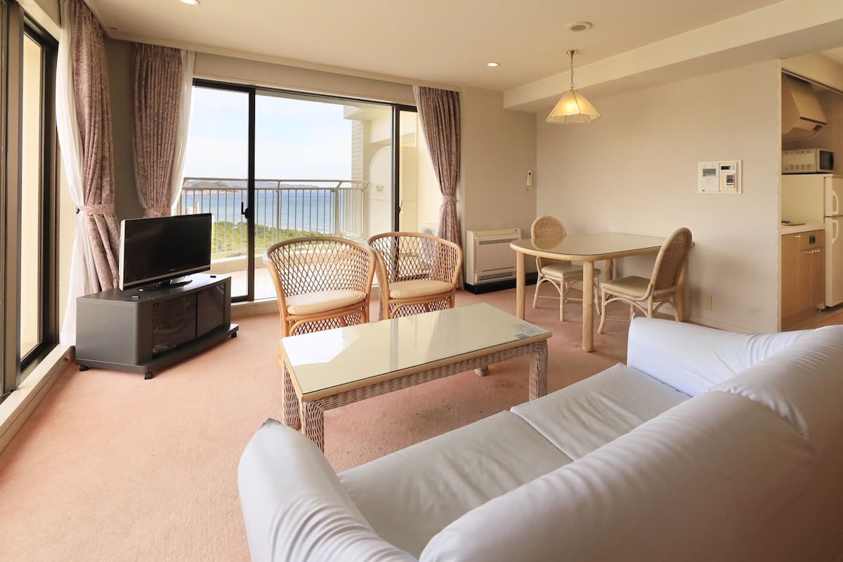 Une chambre d’hôtel moderne dotée d’un balcon, d’un coin repas et d’une kitchenette.
