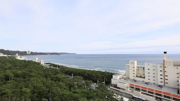 A coastal cityscape with a view of the ocean, a highway, and a mix of residential and commercial buildings.