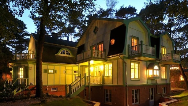 A large, multi-story house with a balcony, a staircase, and a well-lit front porch. - Country house Victoria, Seahorse (Ostseebad Boltenhagen)