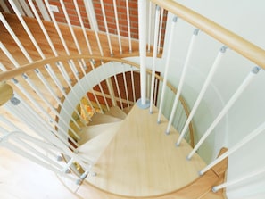 Eine Wendeltreppe mit weißen Geländern und Holzstufen.