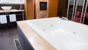 Een moderne badkamer met een groot bad, een wastafel en een spiegel erboven.