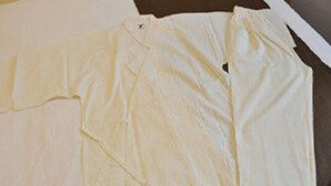 A plain white shirt laid out on a flat surface.