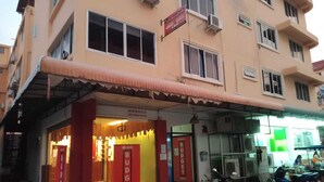 A hotel with a red facade, multiple windows, and a sign for 'The Best Budget Hotels'. - The Best Budget Hotel (Pattaya)
