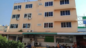 A multi-story building with several air conditioning units, a satellite dish, and a sign indicating a 24-hour service. - The Best Budget Hotel (Pattaya)