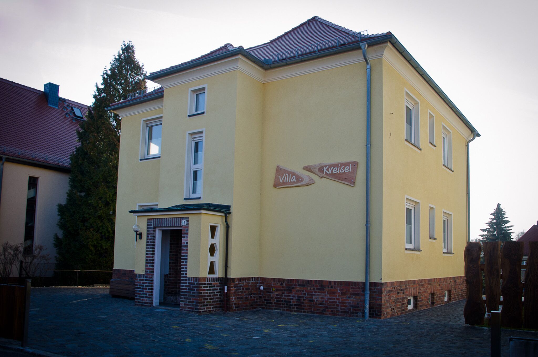 Un edificio amarillo con un letrero que dice "Villa Kreisel".