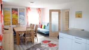 Un salon moderne comprenant une table à manger, des chaises, un canapé et un coin cuisine.