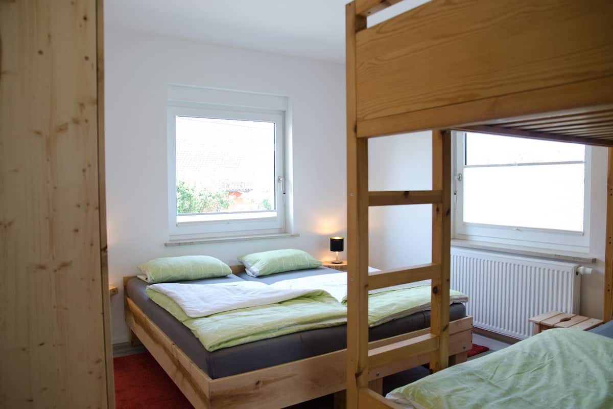 A room with bunk beds, a window with a view, and a radiator.