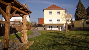 Un bâtiment à deux étages, doté d’un toit en pente, d’une clôture en bois et d’un chemin pavé menant à l’entrée.