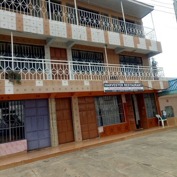 A two-story building with a sign for "HARVESTER RESTAURANT" indicating available accommodation. - Harvester Restaurant (Nakuru)