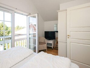 A bedroom with a bed, a desk with a television, and a chair. - 5 Star Holiday Home in Blavand (Blavand)