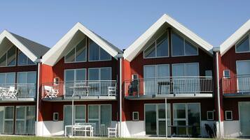 A multi-story building with balconies, large windows, and a flat roof.