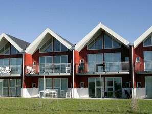 Un immeuble moderne à plusieurs étages, doté de balcons et de grandes fenêtres.