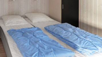 Un lit simple avec un matelas blanc et une literie bleue.