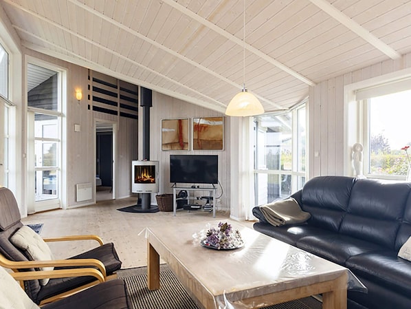 Un salón amplio con chimenea, televisor y una zona de estar acogedora.