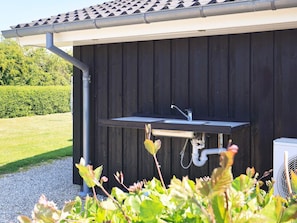 A small outdoor kitchen with a sink and a fan. - 4 Star Holiday Home in Rudkobing (Rudkobing)