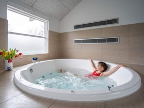 A child in a bathtub with a digital thermometer, a window, and a vent on the wall. - 5 Star Holiday Home in Tisvildeleje (Vejby)