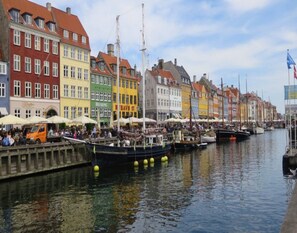 A waterfront with colorful buildings, boats docked along the canal, and people gathered near the water. - Serene Holiday Home in Fanø near Restaurants (Fano)