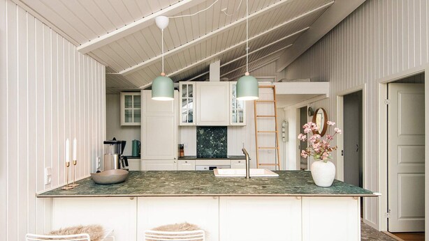 A modern kitchen with white cabinetry, a granite countertop, and pendant lights. - Cozy Holiday Home in Fanø near Beach (Fano)