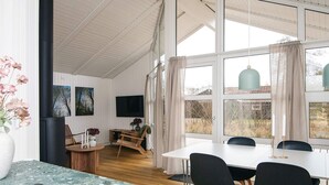 A modern dining area with a large table, black chairs, and a stone countertop. - Cozy Holiday Home in Fanø near Beach (Fano)