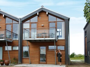 A modern two-story building with large windows and a balcony. - 5 Star Holiday Home in Bogense (Bogense)