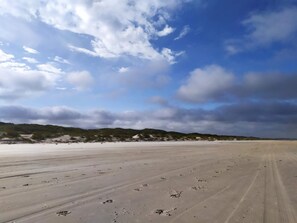 A wide, open sandy beach with gentle dunes in the background under a partly cloudy sky. - 4 Star Holiday Home in Bindslev (Bindslev)