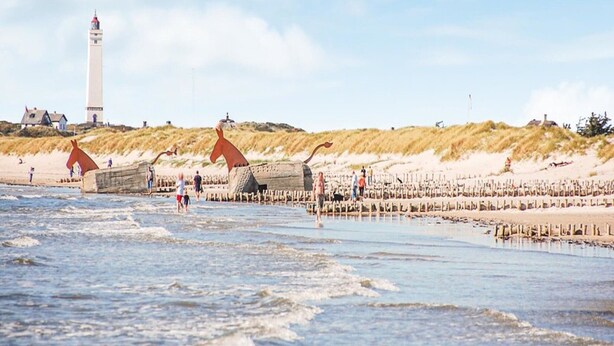 A beach with a lighthouse, dunes, and a wooden pier. - Luxury Retreat With Spa - By Traum Ferienwohnungen (Blavand)