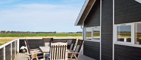 A deck with outdoor furniture and a view of the landscape.