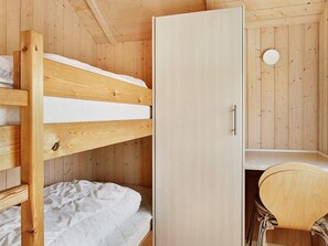 A compact room with a bunk bed, a wardrobe, and a small desk with a chair. - 5 Star Holiday Home in Storvorde (Storvorde)
