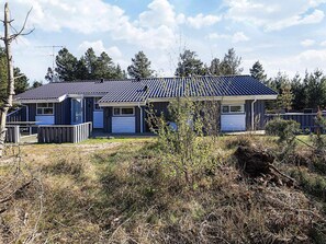 A two-story house with a dark roof and a garage. - 4 Star Holiday Home in Albaek (Aalbaek)