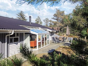 A house with a covered patio, a deck, and a chimney. - 4 Star Holiday Home in Albaek (Aalbaek)