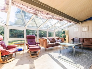 A sunroom with a glass ceiling, leather furniture, and a view of the outdoors. - 4 Star Holiday Home in Albaek (Aalbaek)