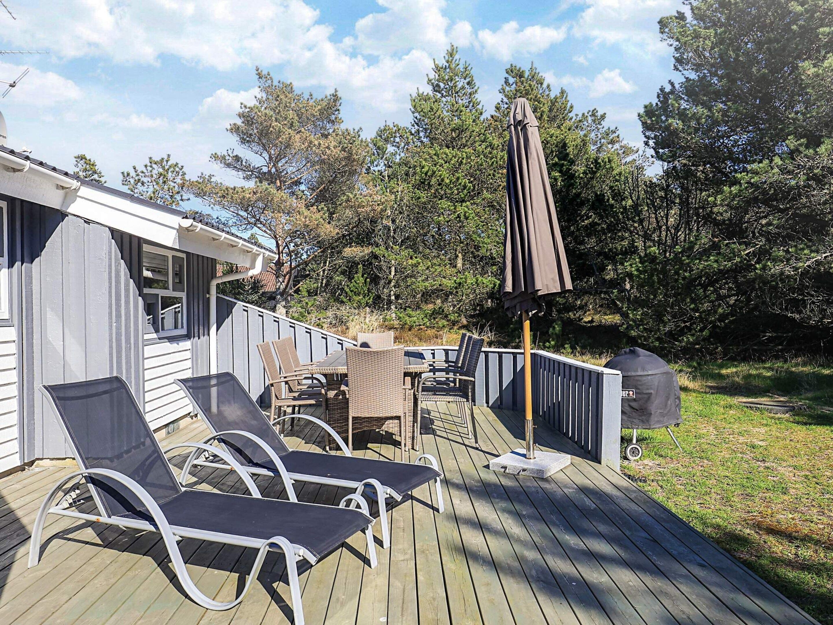 En terrasse med liggestole og grill.