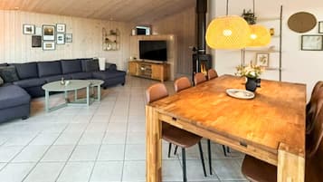 Un salon moderne avec une table à manger en bois, un canapé et un téléviseur.