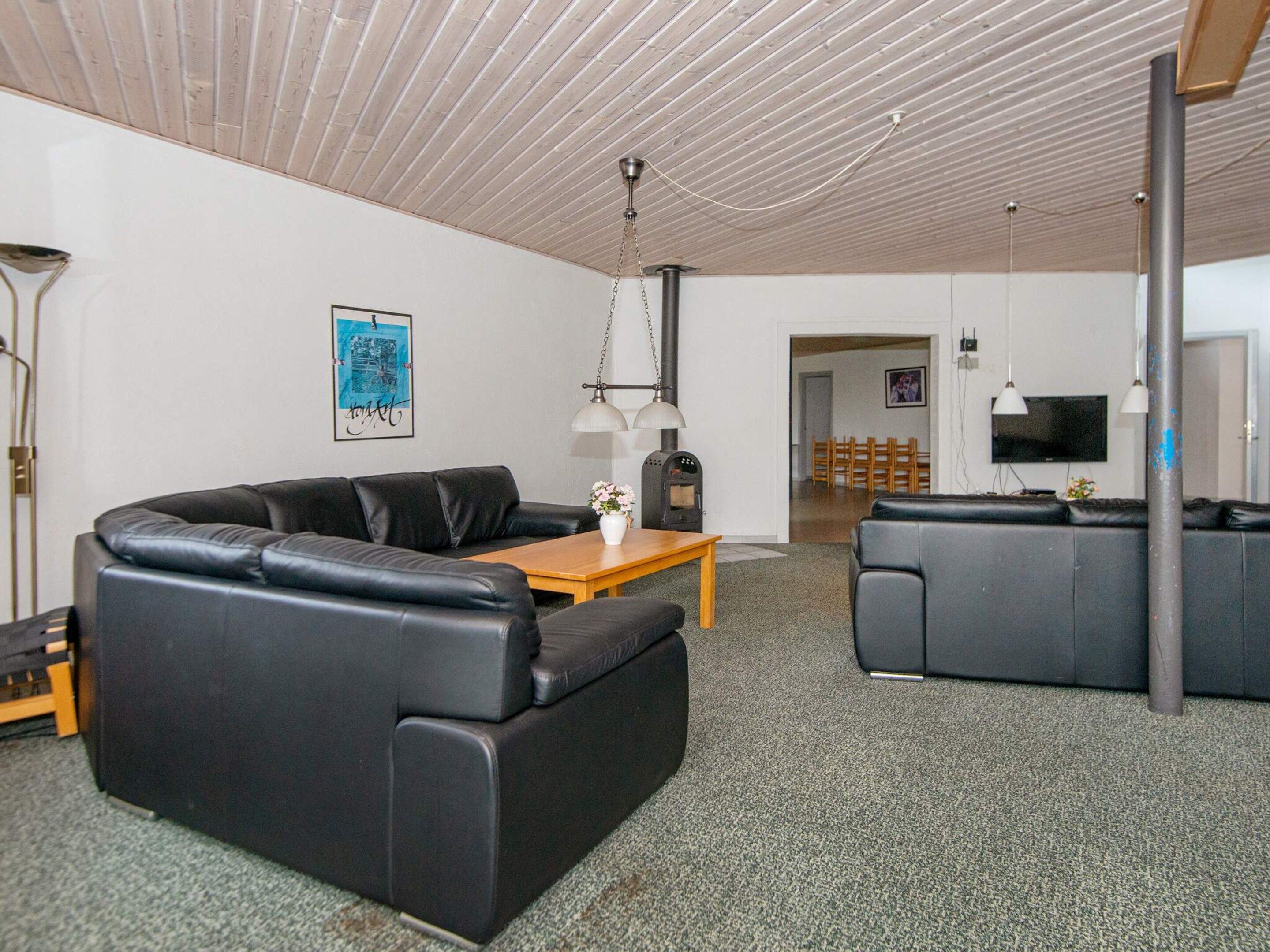 A modern living room with a sofa, a wooden coffee table, and a television.