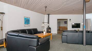 A modern living room with a sofa, a wooden coffee table, and a television.