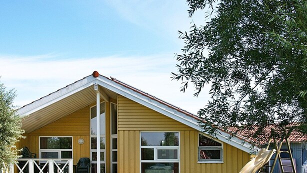 A yellow building with a gabled roof, large windows, and a slide in the yard. - Holiday Home in Otterndorf (Otterndorf)
