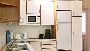 A compact kitchen with a microwave, coffee maker, and a refrigerator. - Holiday Home in Otterndorf (Otterndorf)