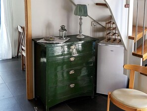 A green chest of drawers with a lamp on top, a small refrigerator, a chair, and a staircase. - Holiday Home in TvÃ¥Ã¥ker (Tvaaker)