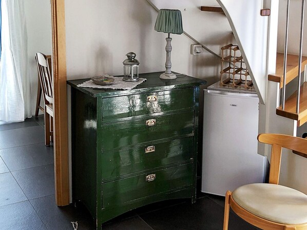 A green chest of drawers with a lamp on top, a small refrigerator, a chair, and a staircase. - Holiday Home in TvÃ¥Ã¥ker (Tvaaker)