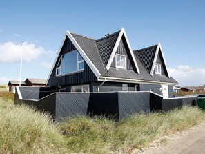 A modern two-story house with a steeply pitched roof and large windows. - 4 Star Holiday Home in Blokhus (Blokhus)