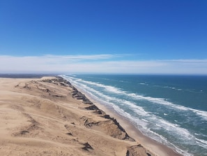 A coastal landscape with a sandy beach and ocean waves.