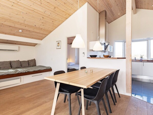A modern interior with a dining area, a kitchen, and a living space.