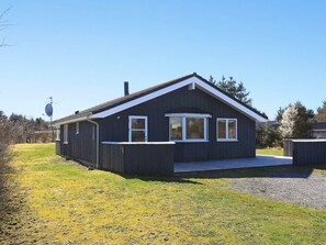 A modern two-story house with a dark exterior, white trim, and a sloped roof.