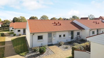 Ein Wohngebäude mit rotem Ziegeldach, befestigter Auffahrt und kleinem Garten.
