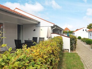 A residential house with a covered patio, a small garden, and a pathway leading to another house. - 4 Person Holiday Home in Aeroskobing (Aeroskobing)