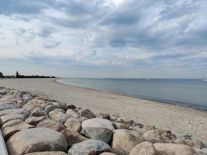 Ein Strand mit felsigem Ufer und ruhiger See.