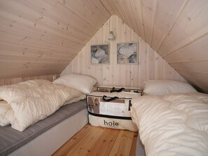 A small, cozy attic bedroom with two beds, wooden walls, and a sloped ceiling. - 4 Star Holiday Home in Karrebaeksminde (Karrebæksminde)