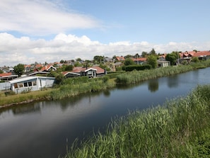 A calm river with houses on one side and a grassy area on the other. - 4 Star Holiday Home in Karrebaeksminde (Karrebæksminde)