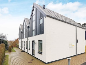 A modern building with a white facade, black trim, and a sloped roof. - 4 Star Holiday Home in Vaeggerlose (Vaeggerlose)